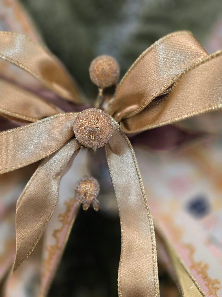 Close-up of a decorative bow with ribbons and small balls on a blurred background