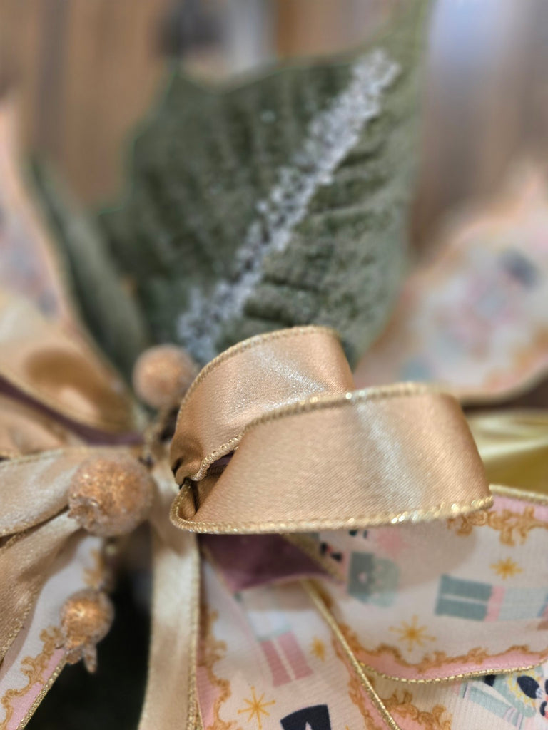 Close-up of a decorative bow with gold ribbon on a blurred background