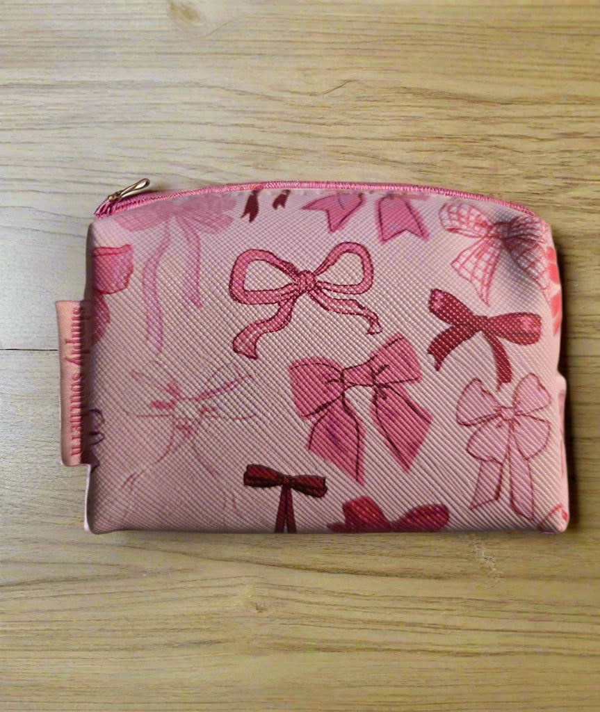 Pink pouch with bow pattern on a wooden surface