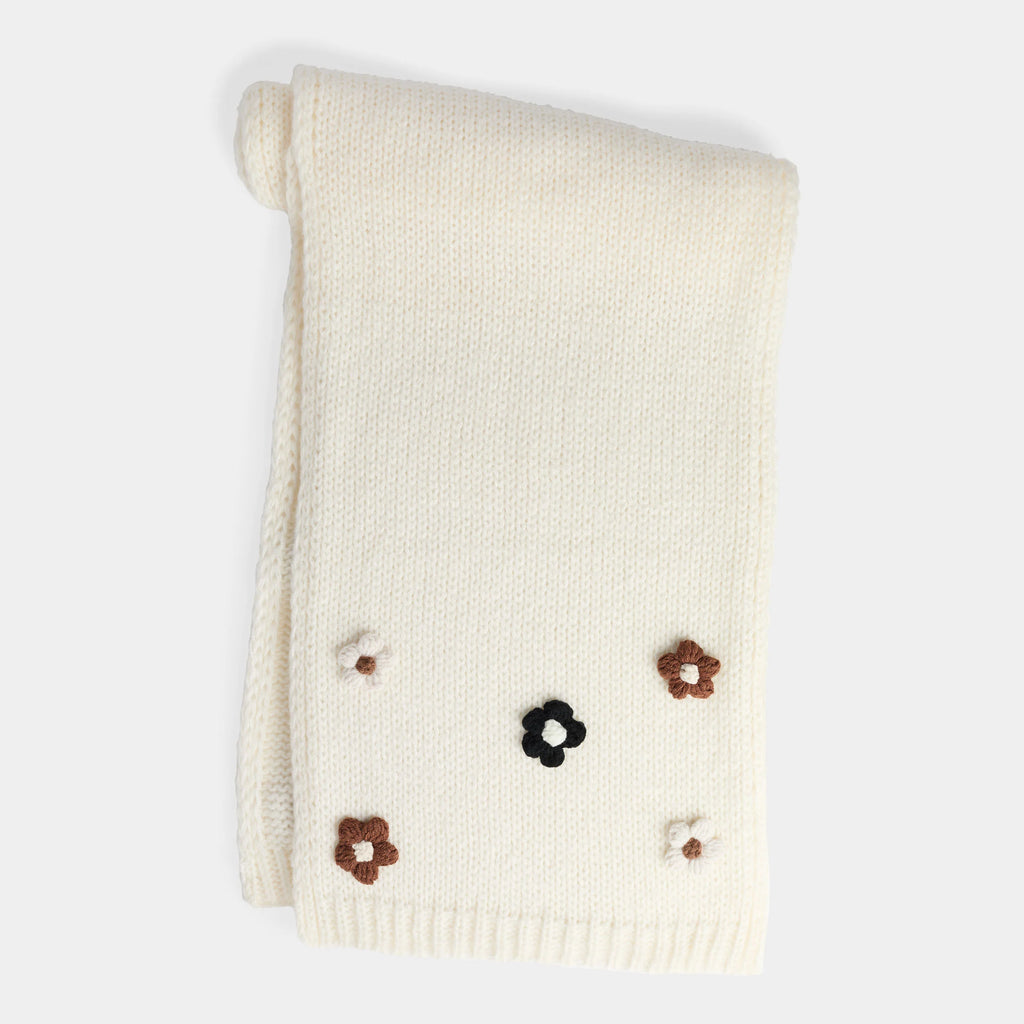 Soft knit scarf with delicate flower embellishments, cozy and feminine winter accessory.