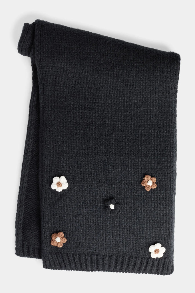 Soft knit scarf with delicate flower embellishments, cozy and feminine winter accessory.