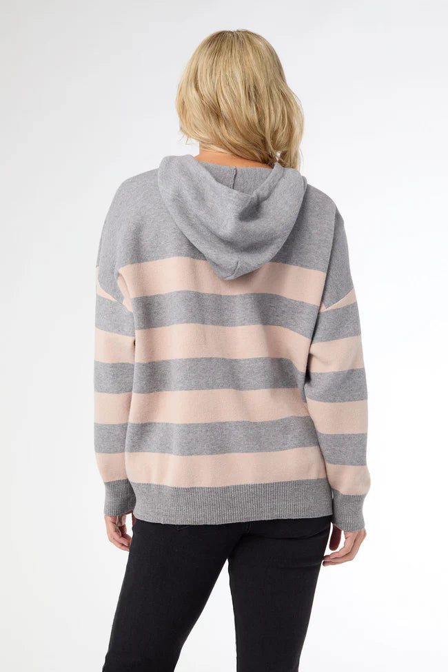 Person wearing a gray and pink striped hoodie on a white background