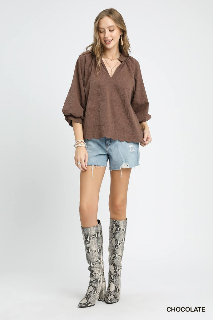 Close-up of scalloped hemline and waffle texture on blouse