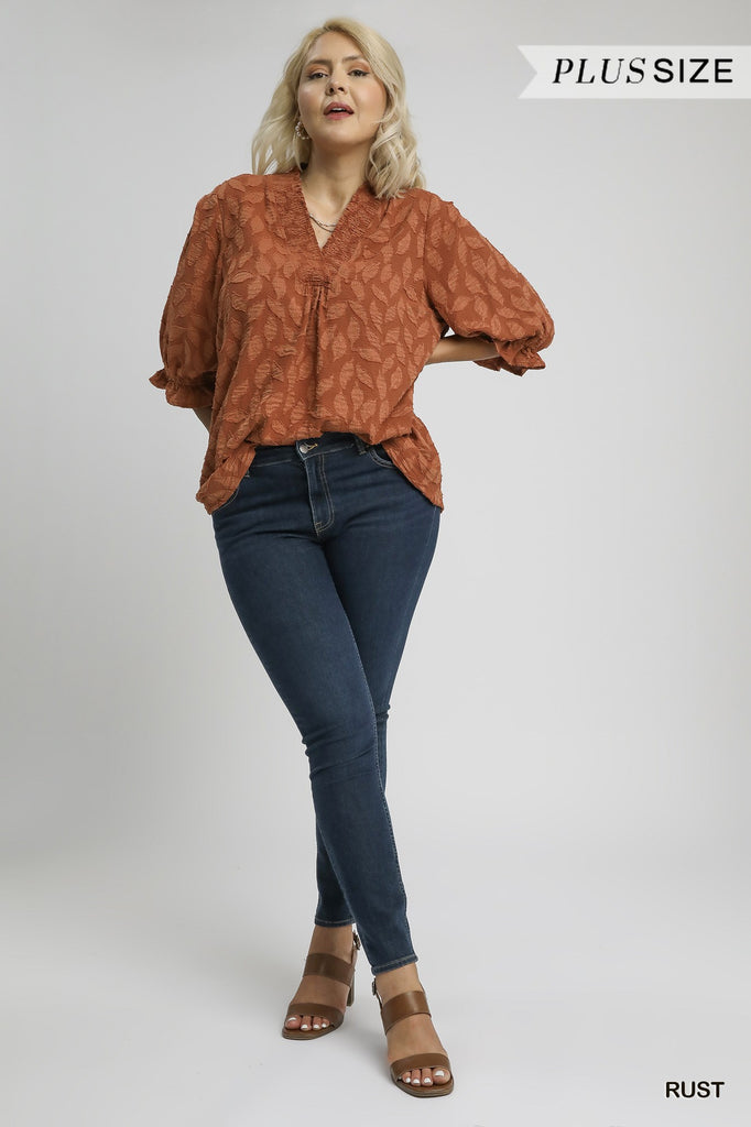 Woman wearing rust Floral Jacquard V-Neck Top with ruched neckline and ¾ sleeves