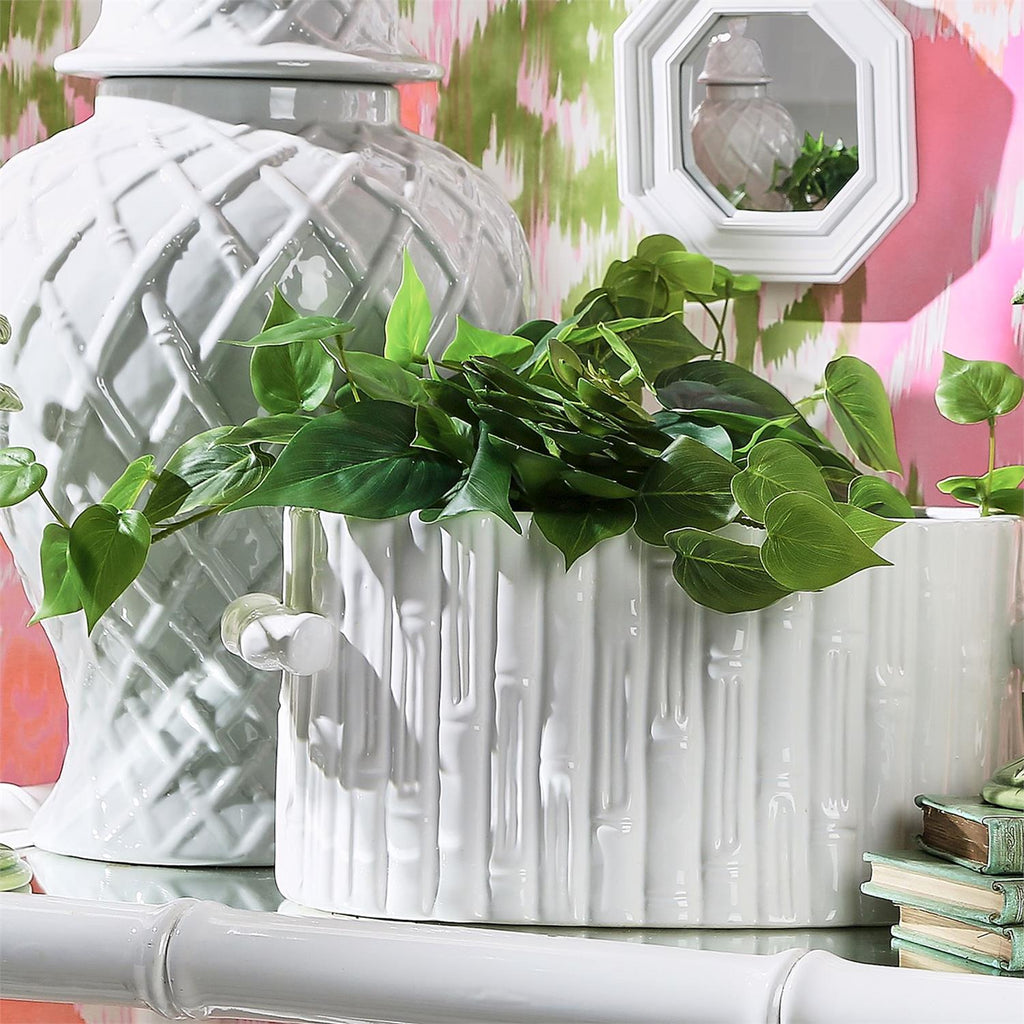 White ceramic faux bamboo tub used as planter with greenery