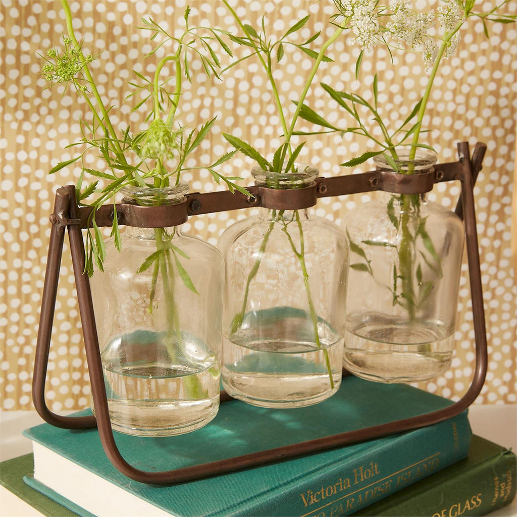 Flower arranger with three glass bottle vases on metal stand