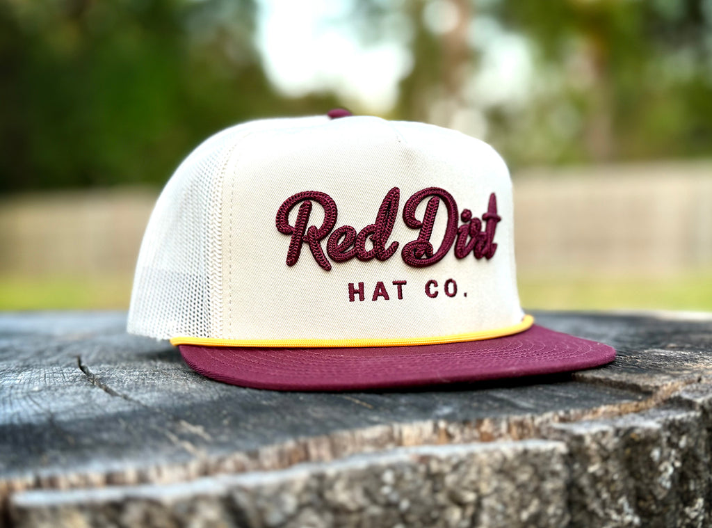 Red Dirt Hat Co. Cowboy Roy Cap with cream front, maroon bill, yellow rope, and white mesh back