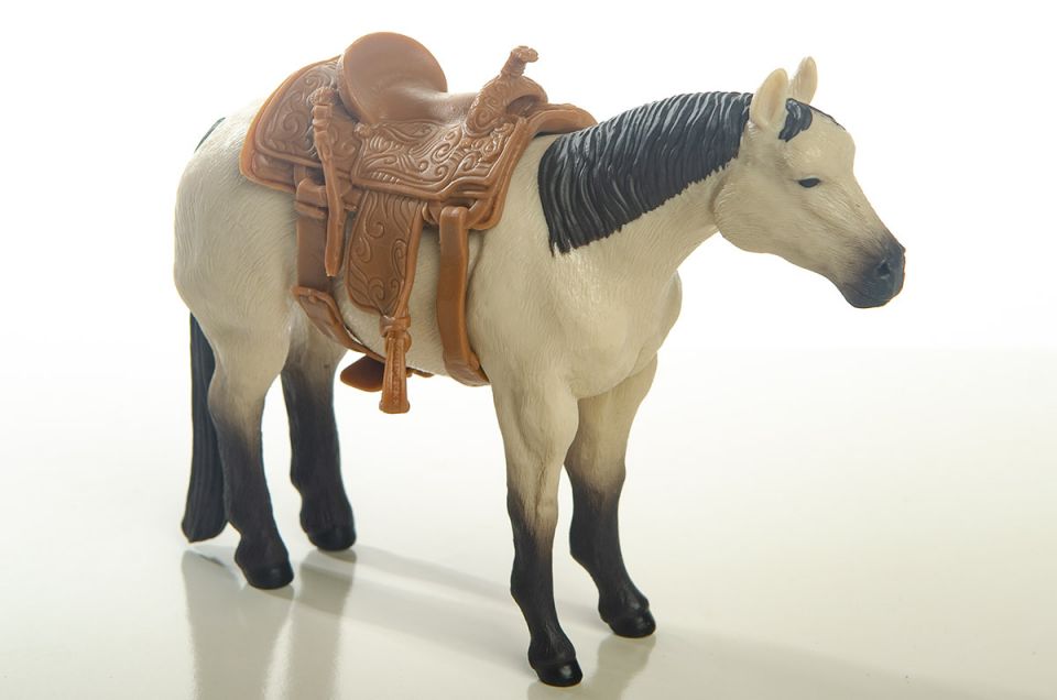 Little Buster Toys calf roping saddle with realistic tooling and stirrup details
