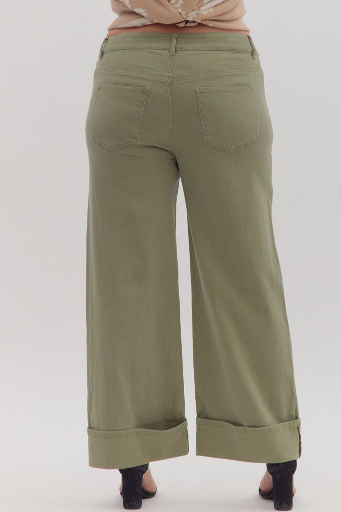 Green wide-leg pants worn by a person on a white background