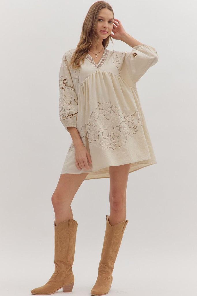Floral embroidered mini dress with 3/4 sleeves, V-neckline, and eyelet sleeve cutouts in cream.
