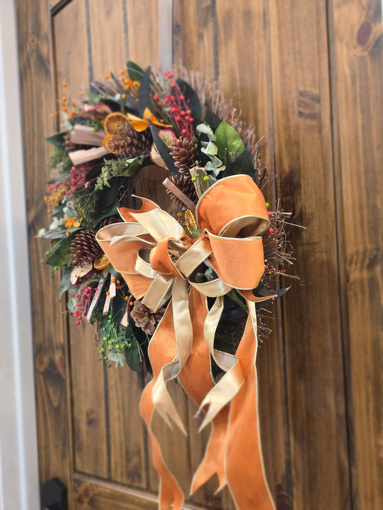 Decorative wreath with ribbons and foliage on a wooden surface